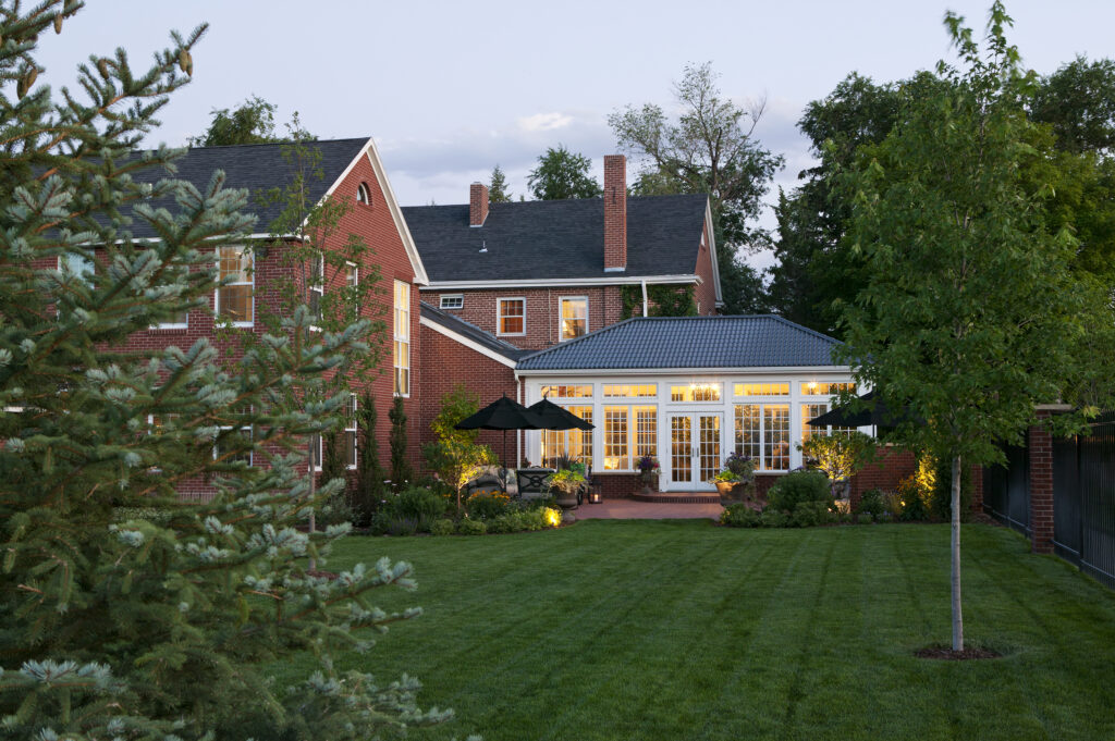 A beautifully renovated orangerie, bathed in sunlight, with elegant architectural features and lush greenery inside. The large windows allow natural light to flood the space, highlighting the intricate detailing of the structure. A harmonious blend of history and modernity, this remodel preserves the charm of the original building while offering a contemporary twist.